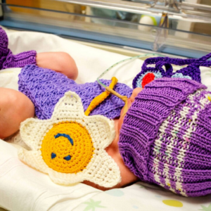 Gli ospiti del centro diurno confezionano abbigliamento per i bimbi prematuri